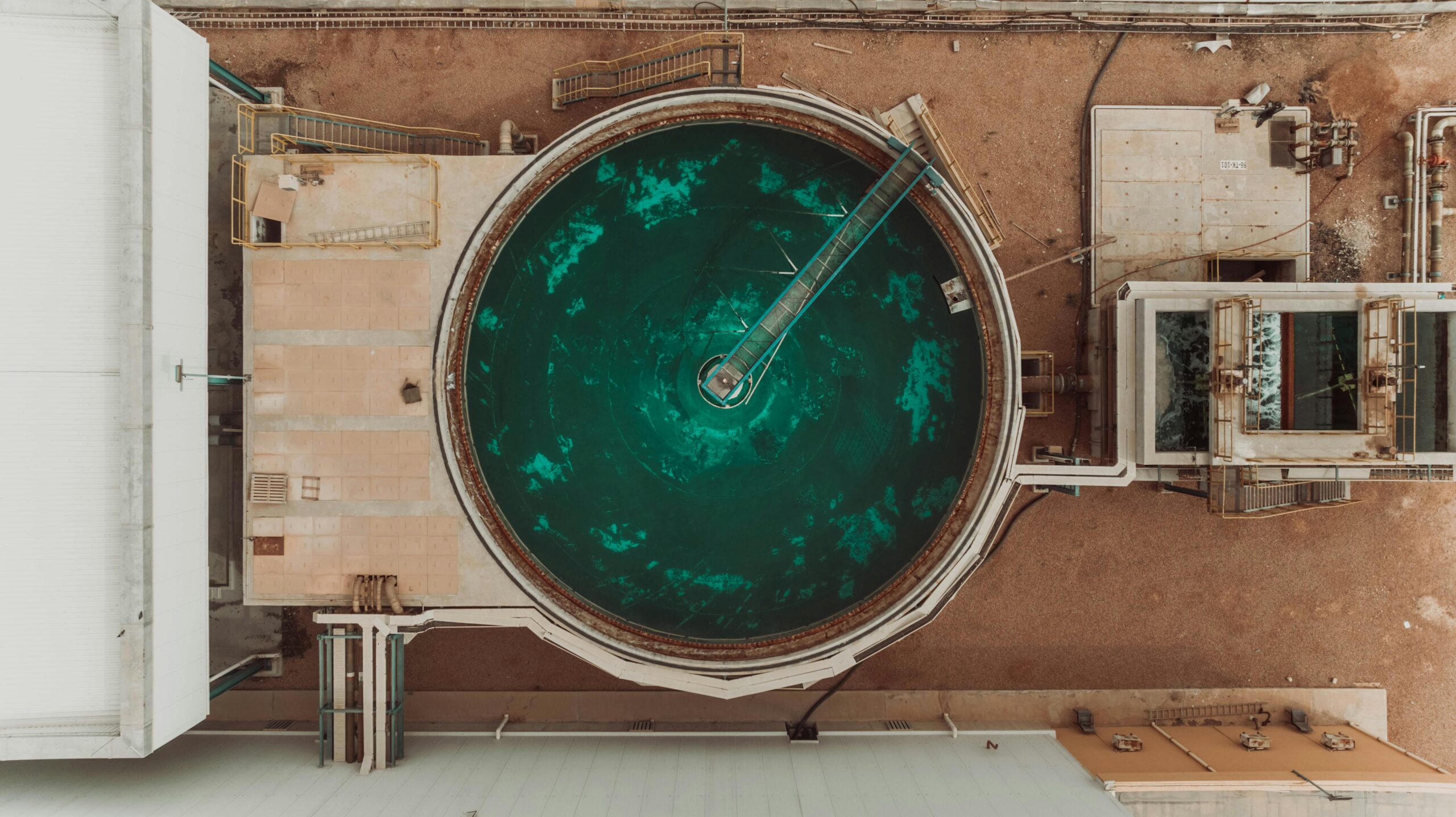 Drone view of a large circular water treatment tank at an industrial facility.
